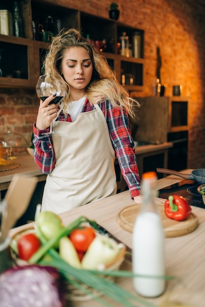 Huisvrouw met glas rode wijn in handen