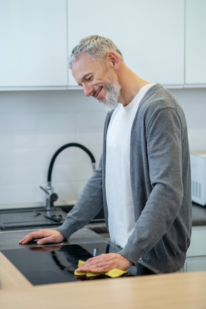 Huiswerk. man in huiskleding die de borden in de keuken afwast