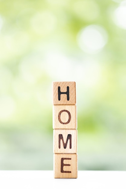 Huiswoord is geschreven op houten kubussen op een groene zomerachtergrond Close-up van houten elementen