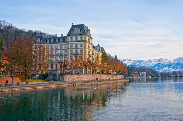 Huizen en bergen aan de kade in de oude binnenstad van Thun. Thun is een stad in het Zwitserse kanton Bern. Het is gelegen waar de rivier de Aare uit het meer van Thun stroomt.