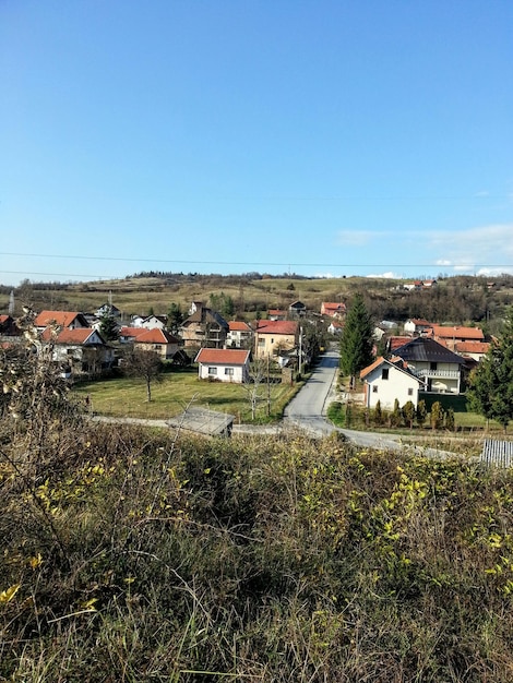 Foto huizen op het veld tegen een heldere blauwe hemel