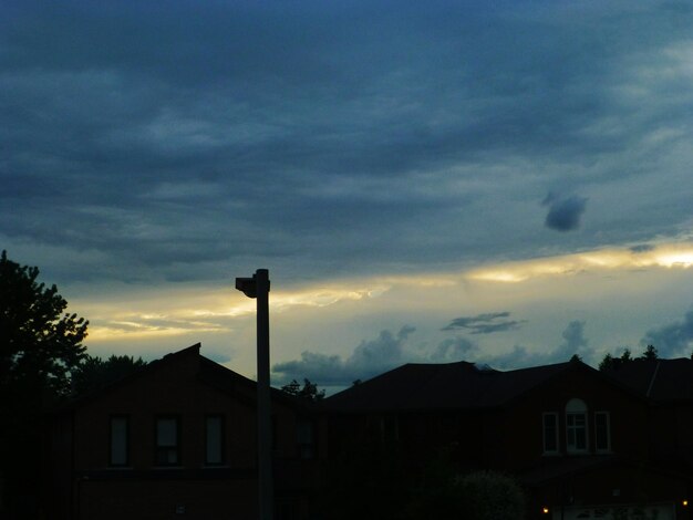 Foto huizen tegen een bewolkte hemel bij zonsondergang