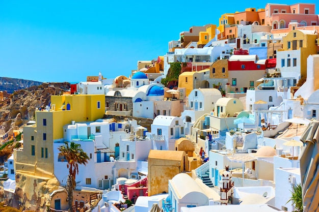 Huizen van verschillende kleuren in Oia, Santorini, Griekenland