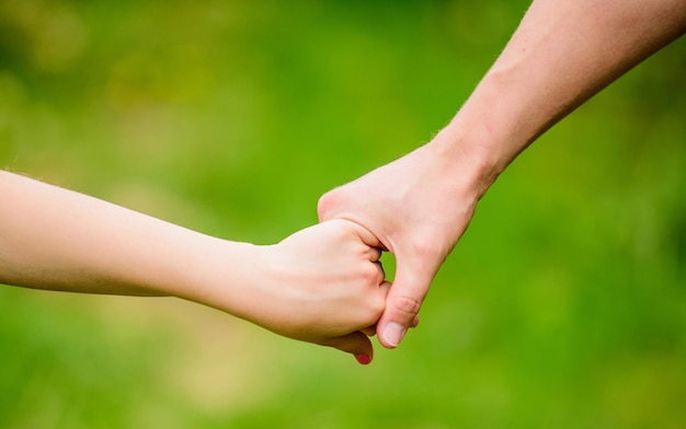 Hulp en ondersteuning. vader houdt zijn kind met de hand. handen bij elkaar. familiewaarden en liefde. tijd voor gezinsbinding. Handen samen. concept van ondersteunen. ouderschap en ouderschap. veilig voelen.