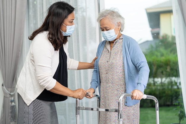 Hulp en zorg aziatische oudere vrouw gebruikt rollator met een sterke gezondheid