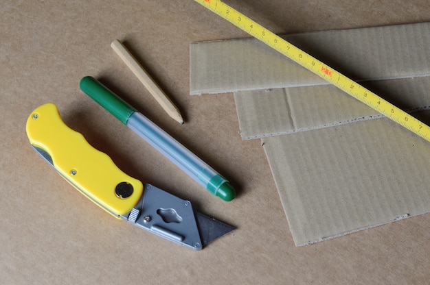 Hulpmiddelen voor het werken met karton dat op een tafel is gelegd met kartonresten.