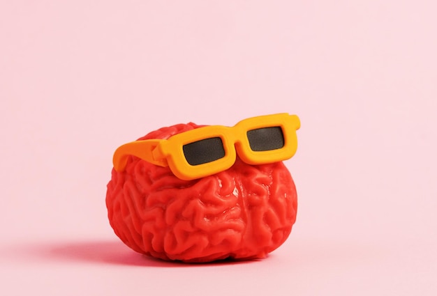 Модель человеческого мозга в солнцезащитных очках на розовом фоне Минимальный художественный плакат
