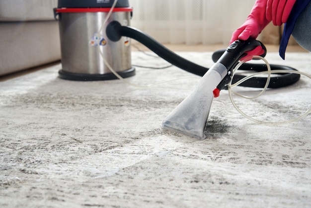 Human Cleaning Carpet In The Living Room Using Vacuum Cleaner At Home