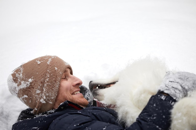 인간과 개는 가장 친한 친구입니다 화창한 날 깊은 눈 속에서 겨울에 눈 덮인 숲에서 남자와 개 산책