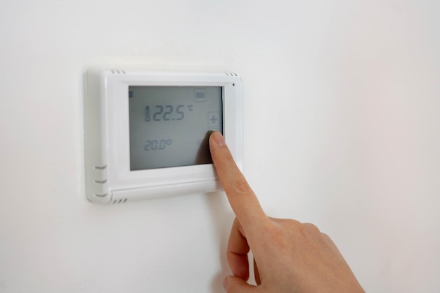 写真 自宅でデジタル中央暖房温度計を人手で調整する
