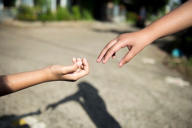 Human hand giving helping hand with blurred background