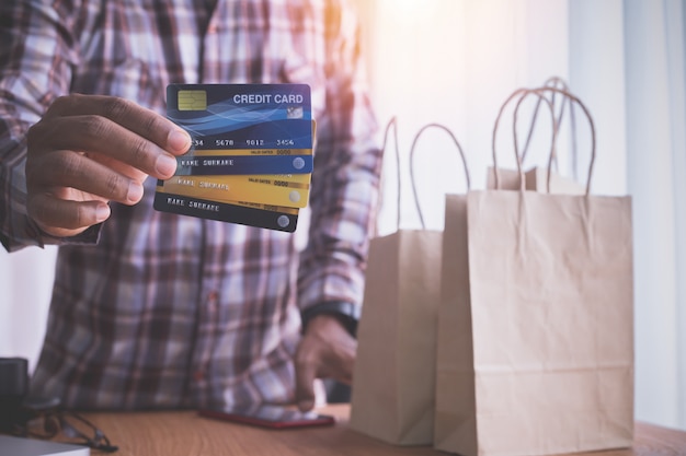 human hand hold credit cards with kraft paper bags