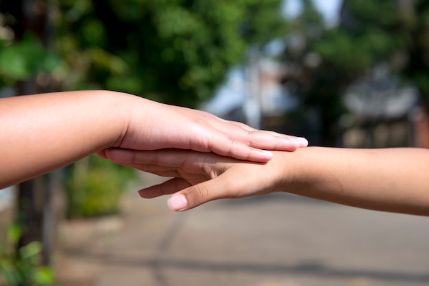 Human hand holding another hand with blurred background