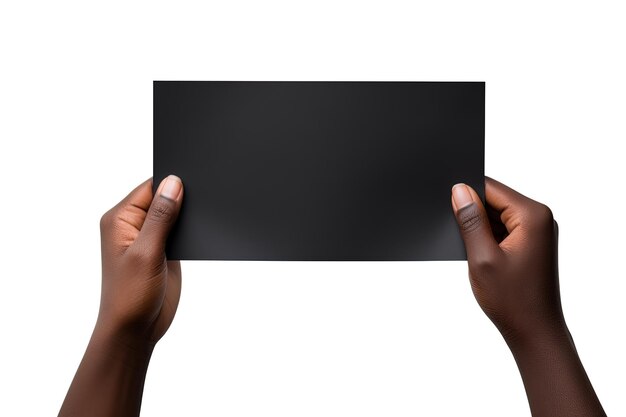 Photo a human hand holding a blank sheet of black paper or card isolated on white background