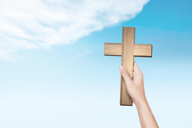 Human hand holding Christian cross