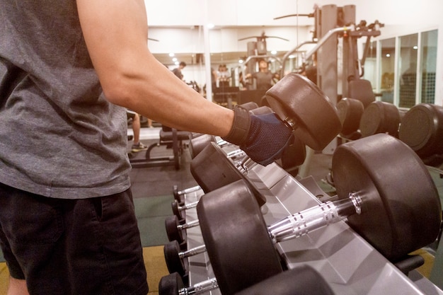 Human Hand holding dumbbell in gym