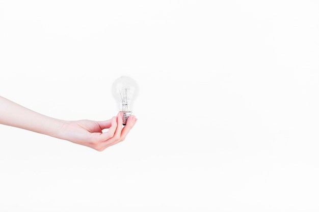 Фото Человеческая рука, держащая лампочку на белом фоне