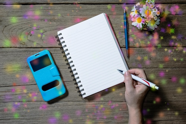 Human hand holding pen with open note book