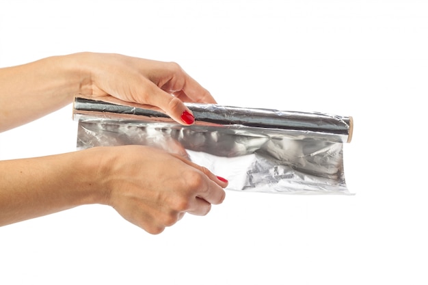 Human hand holding a roll of foil on a white background