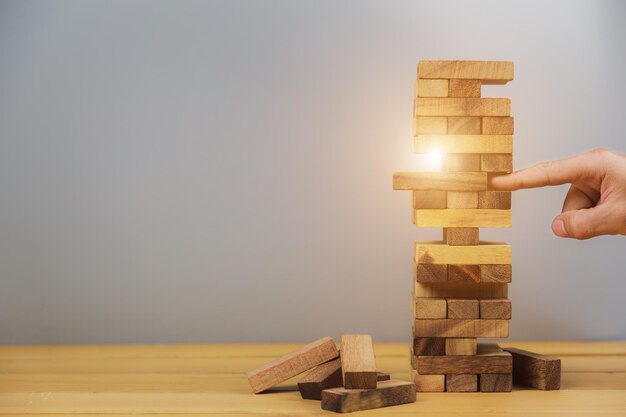 Human hand holding stack of wooden table