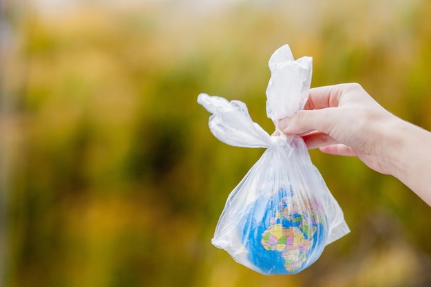 人間の手は地球をビニール袋に入れている プラスチック破片による汚染の概念 温室効果による地球温暖化