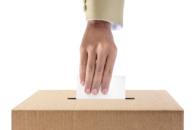 Human hand inserts vote paper into ballot box isolated over white background Election concept