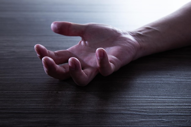 Human Hand of a man unconscious on the floor