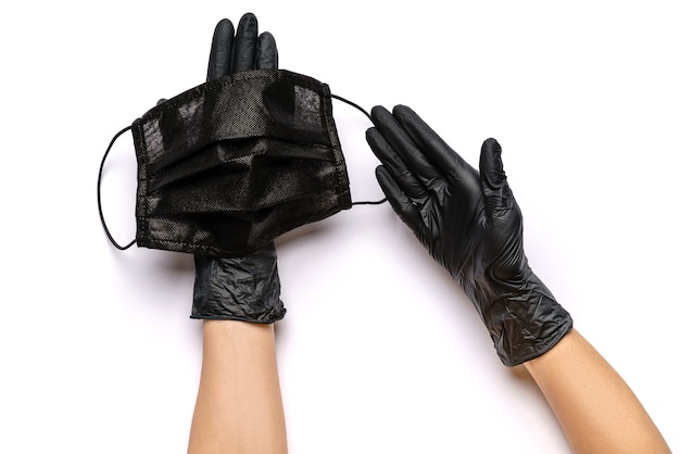 Human hand in protective glove holding face mask