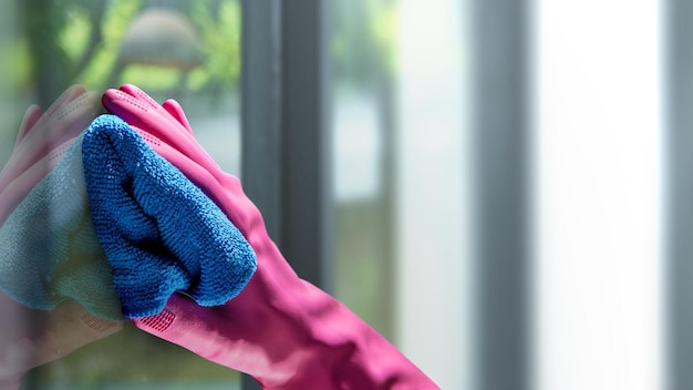 Human hand in protective glove wiping using a cloth