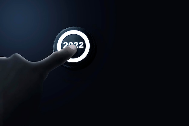 A human hand pushes the 2022 button. Happy New Year 2022