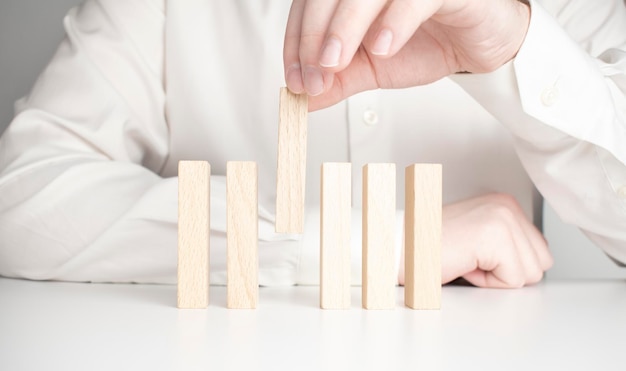 Human hand putting domino in line isolated on white background