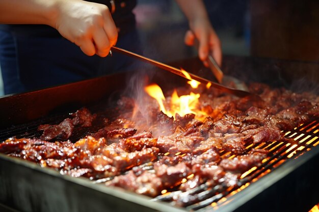 Human hand roasting meat in barbecue grill