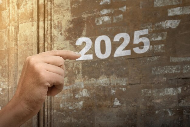 human hand showing number of 2025 on the wall