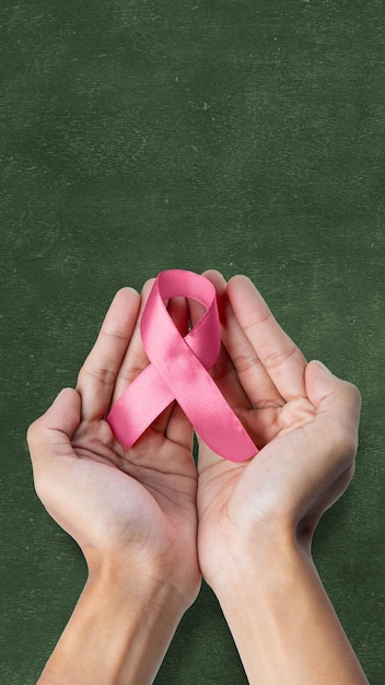 Human hand showing pink awareness ribbon breast cancer awareness concept