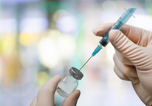 Human Hand with injection Syringe, on  background.