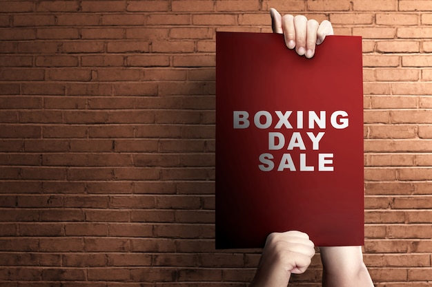 Human hands holding a board with Boxing Day Sale text