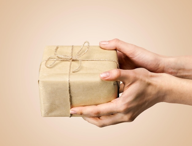 Human hands holding gift on light background