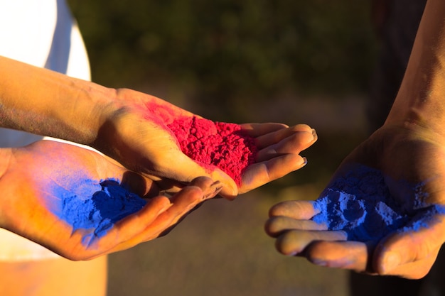 Photo human hands holding red and blue gulal powder. closeup shot