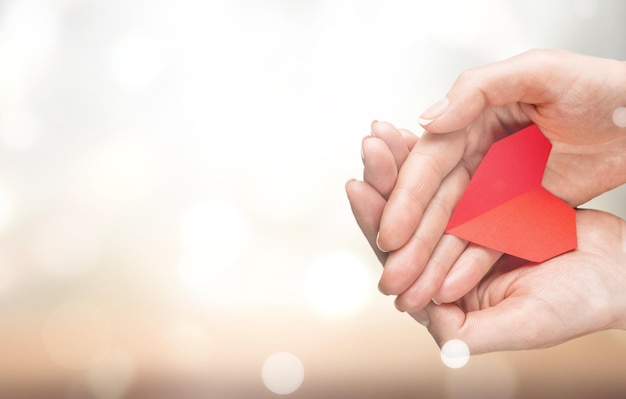 Human hands holding red heart, health care, love and support,