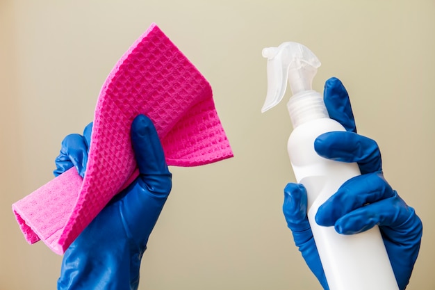 Photo a human hands in protective gloves hold spray disinfectant and cleaning cloth