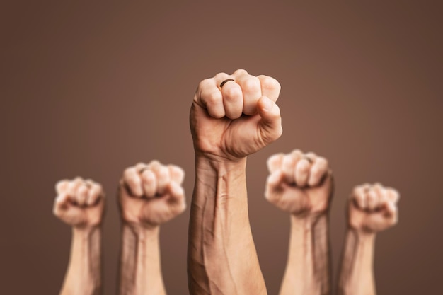 Photo human hands raised with closed fists symbolizing movement.