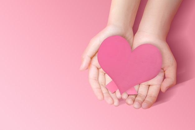 Photo human hands showing a pink heart