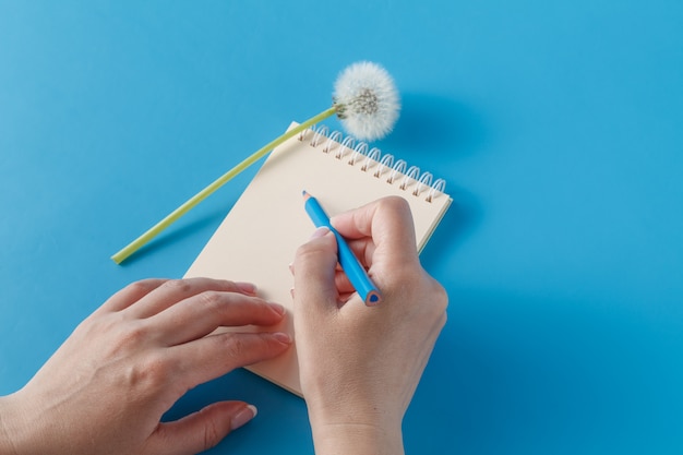 Human hands with pencil writing on paper