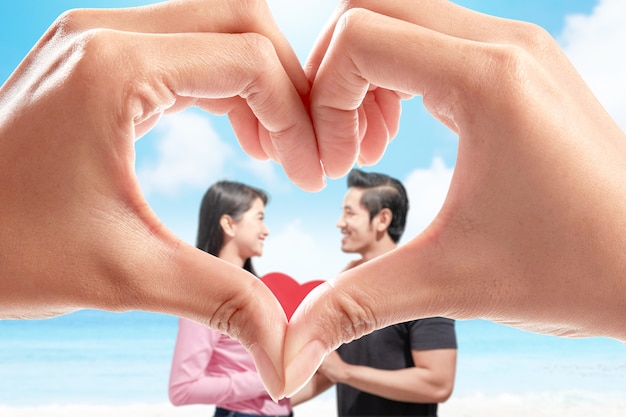 Human hands with the shape of the heart showing Asian couples holding the red heart