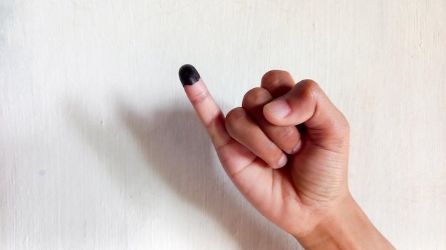 Human little finger after voting in the Indonesian presidential election on a white background