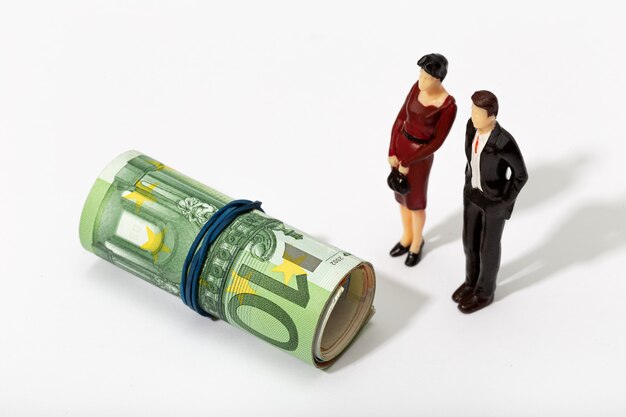 Human representation of a couple looking at a Roll of money. Finance, investment or savings concept