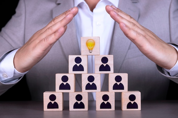 Human resources and corporate hierarchy concept, recruiter team consists of one leader, CEO represented by golden light bulb and icons.