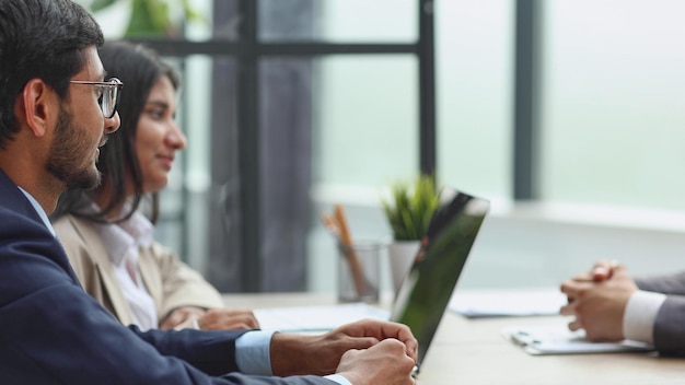 Human resources team sitting in a row at table in office