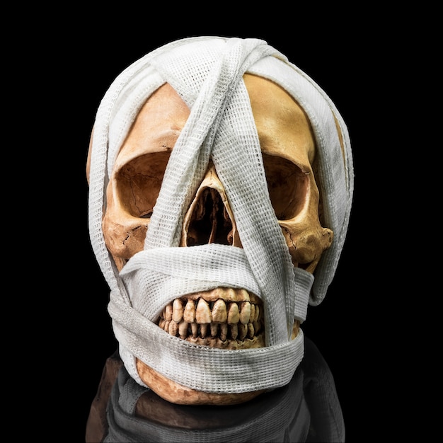 Human skull bind with dirty bandage on dark