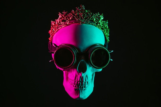 Human skull in steampunk glasses and crown with pink green light